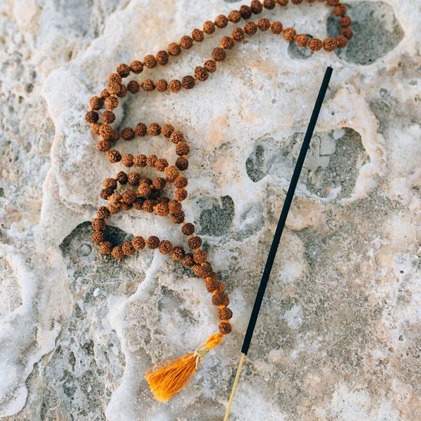Silhouette of a person meditating against a minimalist background with a golden sun.